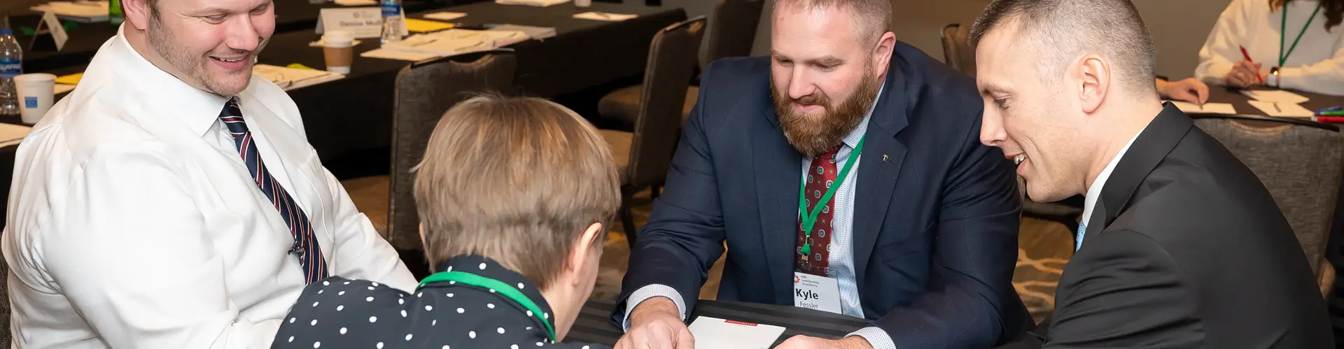 Participants working together at a table during an HRI Leadership Academy session